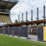 Bouwwerken aan de Zuid-Tribune van Stayen met een discreet STVV-clubanker in het stadion.