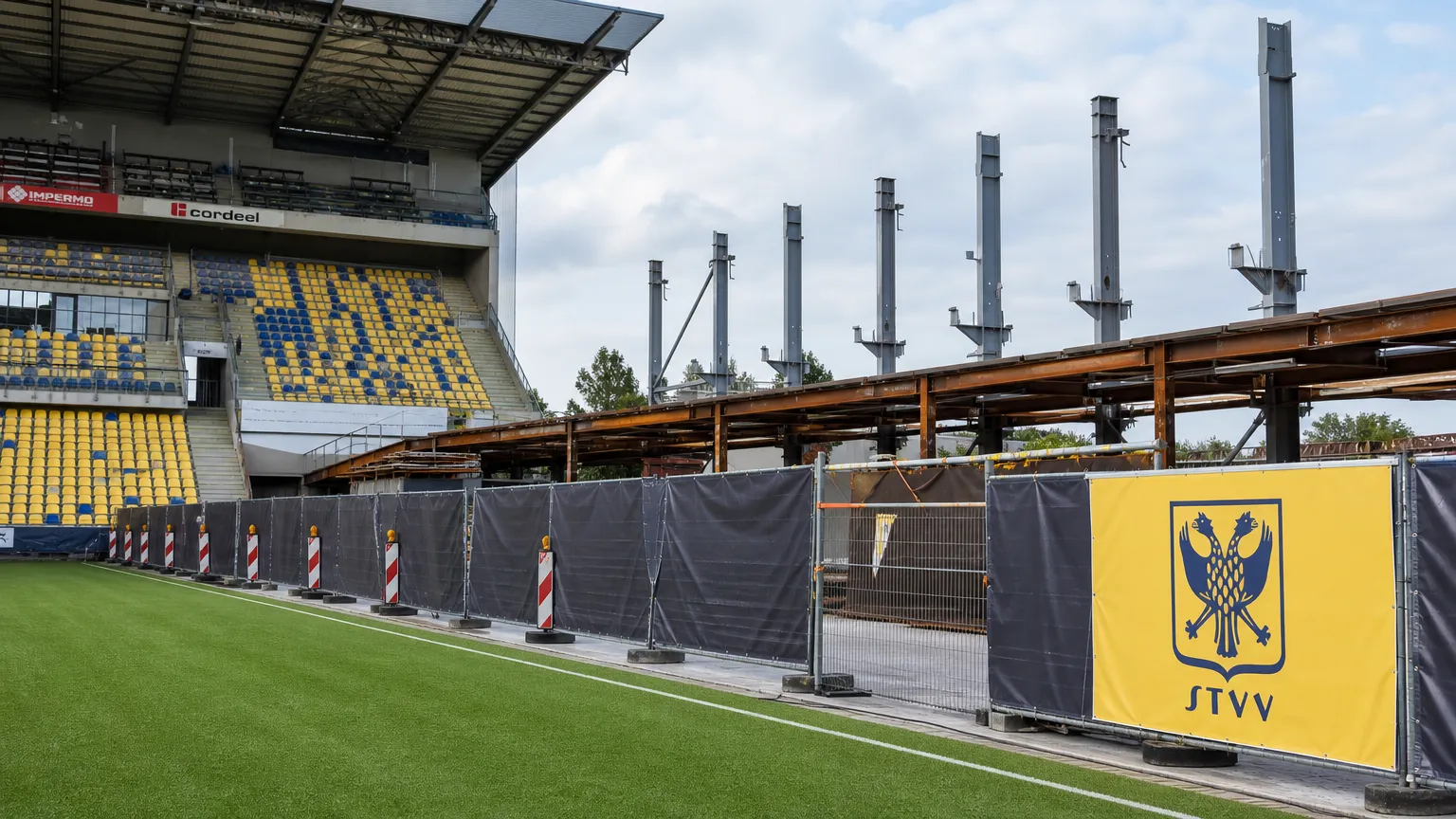 Bouwwerken aan de Zuid-Tribune van Stayen met een discreet STVV-clubanker in het stadion.
