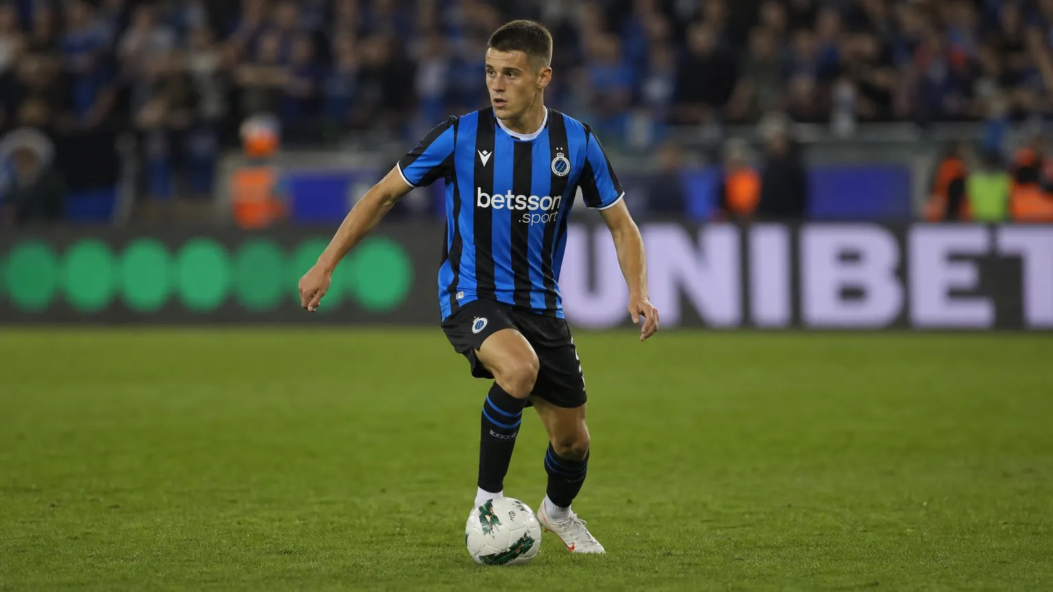 Nicolo Tresoldi in een blauw-zwart wedstrijdshirt tijdens een spelmoment op het veld.