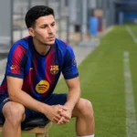 Roony Bardghji zit aan de rand van een trainingsveld in een Barcelona-shirt.