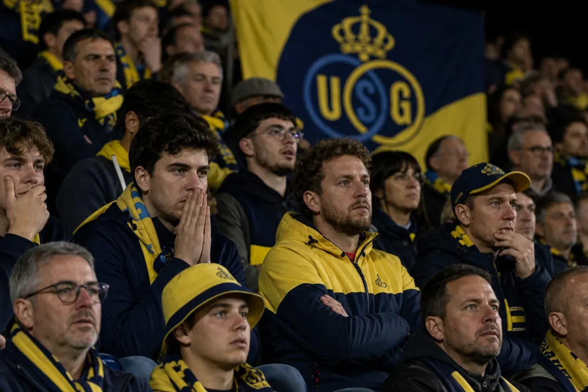 Union-supporters reageren gespannen in een volle stadiontribune.