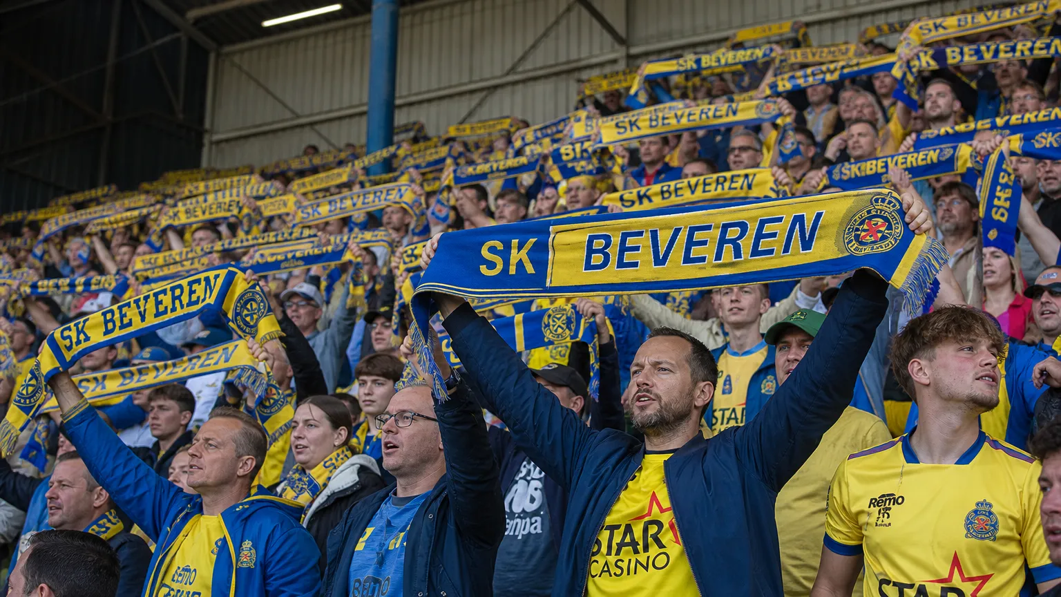 Supporters van SK Beveren met geel-blauwe sjaals in de tribune.