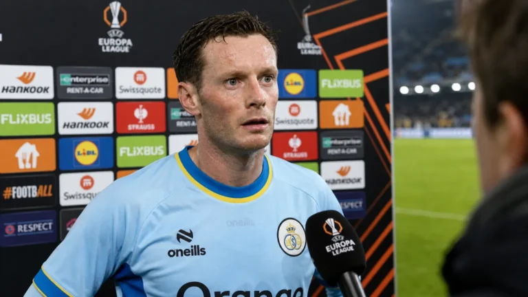 Rob Schoofs in het lichtblauwe shirt van Union tijdens een interview naast het veld.