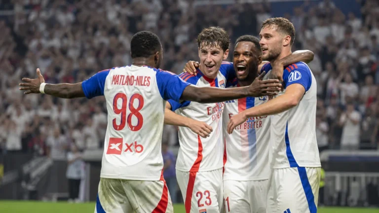 Een groep spelers van Olympique Lyon viert samen op het veld tijdens een Europese wedstrijd.