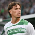 Lucas Stassin in het groen-witte tenue van Saint-Etienne aan de zijlijn van een stadion.