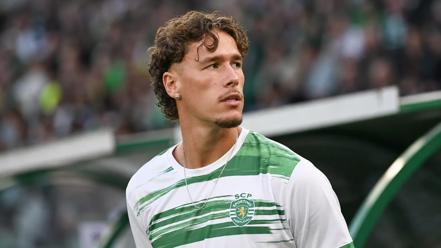 Lucas Stassin in het groen-witte tenue van Saint-Etienne aan de zijlijn van een stadion.