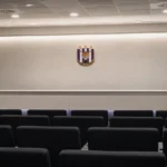 Rustige persruimte met een discreet RSC Anderlecht-embleem op de wand.