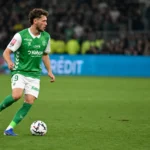 Lucas Stassin in groen-wit tenue van Saint-Étienne met de bal op het veld.