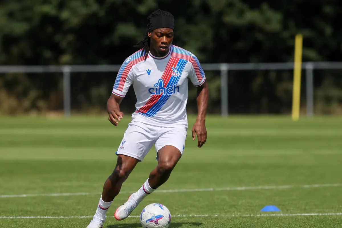 Tayo Adaramola controleert de bal op een trainingsveld in zijn Crystal Palace-kleding.
