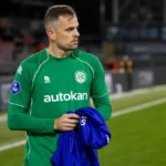 Mats Seuntjens in groen sportshirt langs de zijlijn van een voetbalveld.