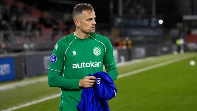Mats Seuntjens in groen sportshirt langs de zijlijn van een voetbalveld.