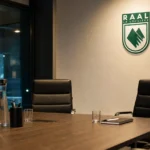 Verlichte vergaderruimte in een clubgebouw met een discreet RAAL La Louvière-embleem aan de wand.