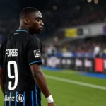 Carlos Forbs van Club Brugge aan de zijlijn van een voetbalveld.