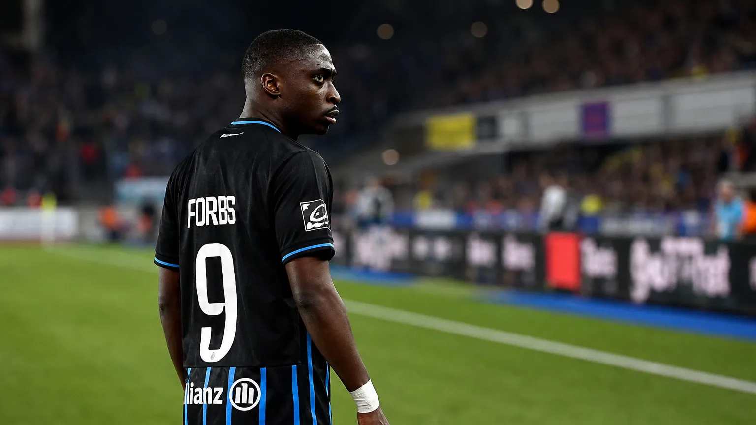 Carlos Forbs van Club Brugge aan de zijlijn van een voetbalveld.
