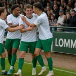 Een groep Lommel SK-spelers viert samen langs het veld.