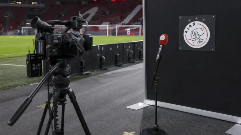 Een televisiecamera staat opgesteld in de interviewzone langs het veld van Ajax.