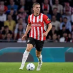 Joey Veerman in een rood-wit gestreept shirt tijdens een wedstrijd op het veld.