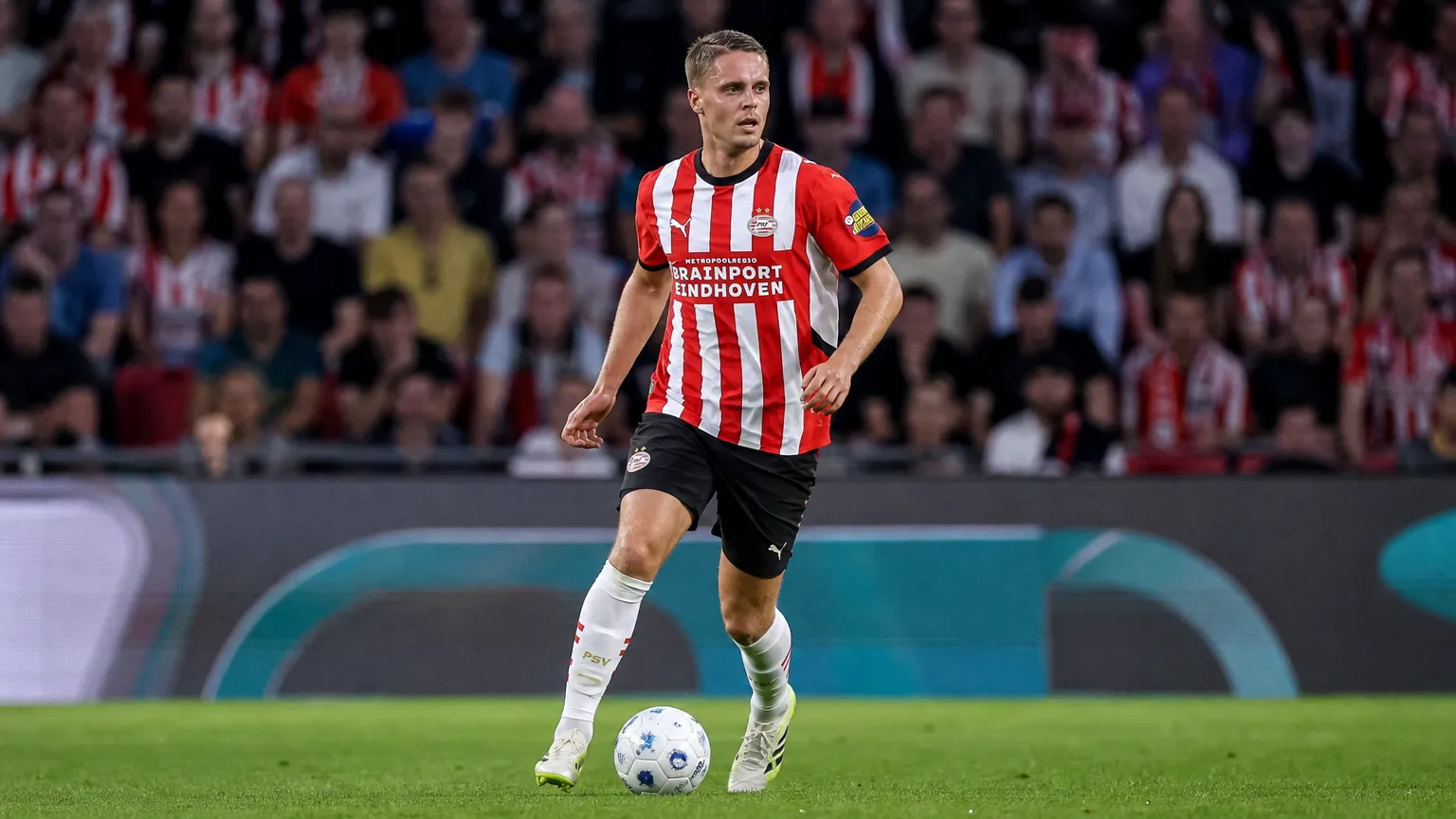 Joey Veerman in een rood-wit gestreept shirt tijdens een wedstrijd op het veld.