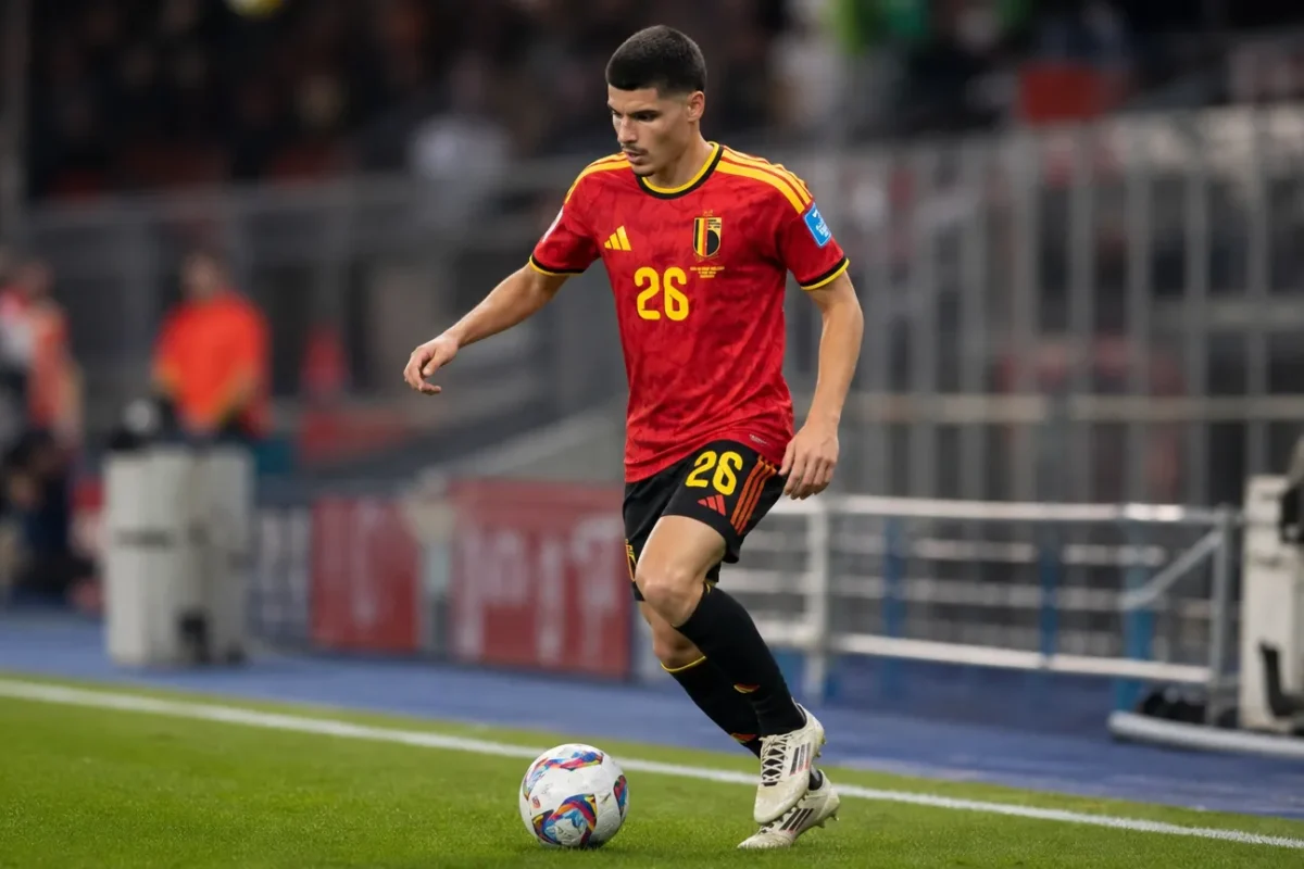 Matias Fernandez-Pardo warmt op in het tenue van de Rode Duivels in een voetbalstadion.