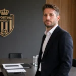 Dries Mertens in een vergaderruimte met een discreet Sporting Hasselt-clubanker.