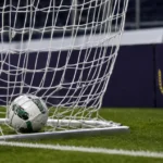 Een bal in het doelnet voor een discreet bord van RSC Anderlecht.