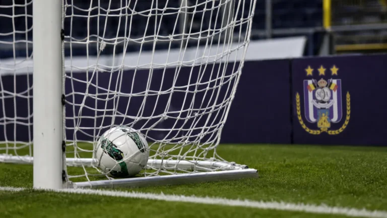 Een bal in het doelnet voor een discreet bord van RSC Anderlecht.