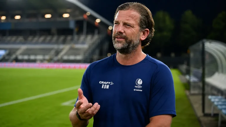 Rik De Mil van KAA Gent spreekt rustig naast een voetbalveld.
