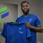 Wilfried Kanga poseert met het shirt van Al-Fateh tijdens een officiële clubpresentatie.