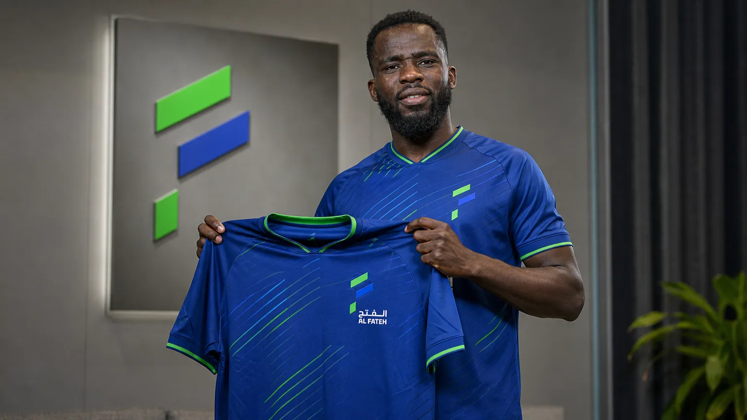Wilfried Kanga poseert met het shirt van Al-Fateh tijdens een officiële clubpresentatie.