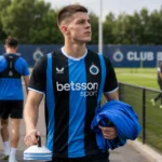 Club Brugge-context aan het trainingscomplex met spelers en staf op de achtergrond.