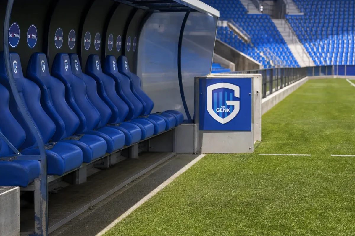 Lege technische zone langs het veld met een discreet KRC Genk-bord.