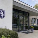 De ingang van een Beerschot-clubgebouw met een discreet clubembleem aan de gevel.