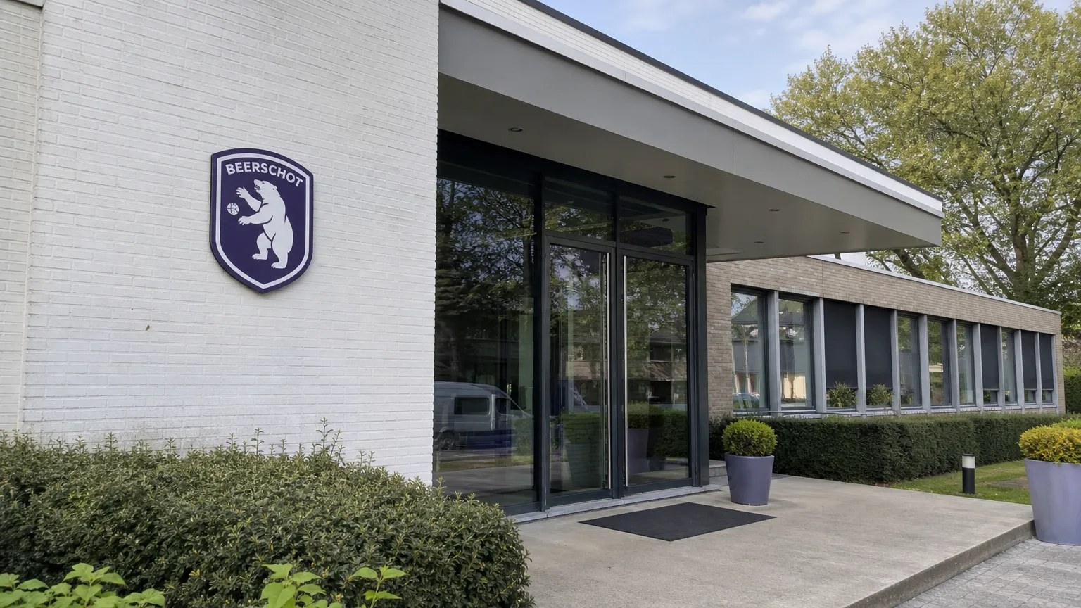 De ingang van een Beerschot-clubgebouw met een discreet clubembleem aan de gevel.