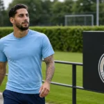 Ludovit Reis in neutrale sportkleding naast een trainingsveld van Club Brugge.