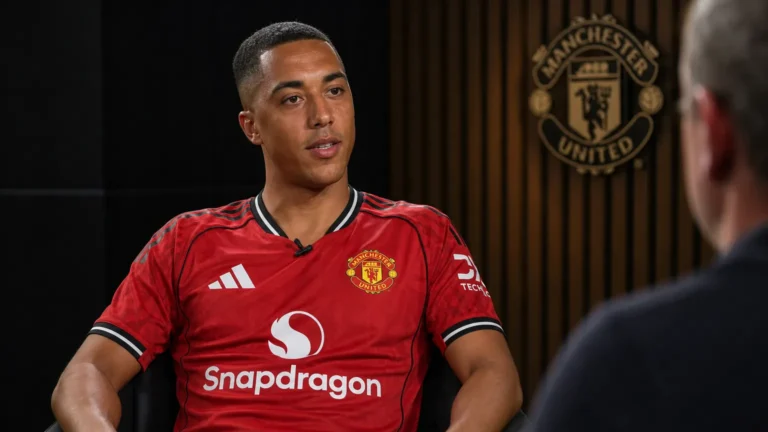 Youri Tielemans tijdens een voetbalinterview in een studio met een discreet Manchester United-wanddetail.