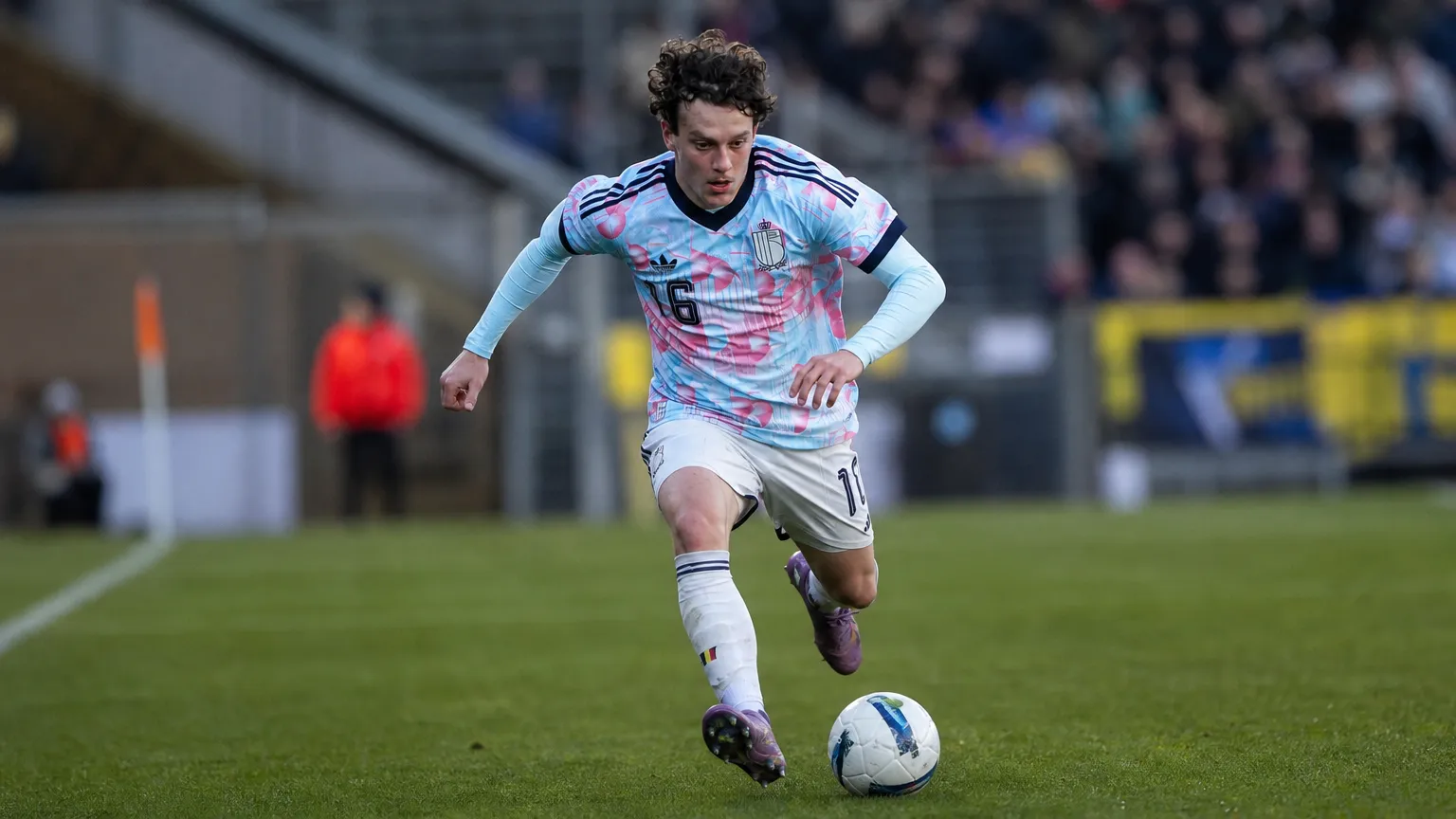Denzel De Roeve in actie in een lichtblauw en roze voetbaltenue.