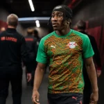 RB Leipzig-context in een spelerstunnel met clubmedewerkers op de achtergrond.