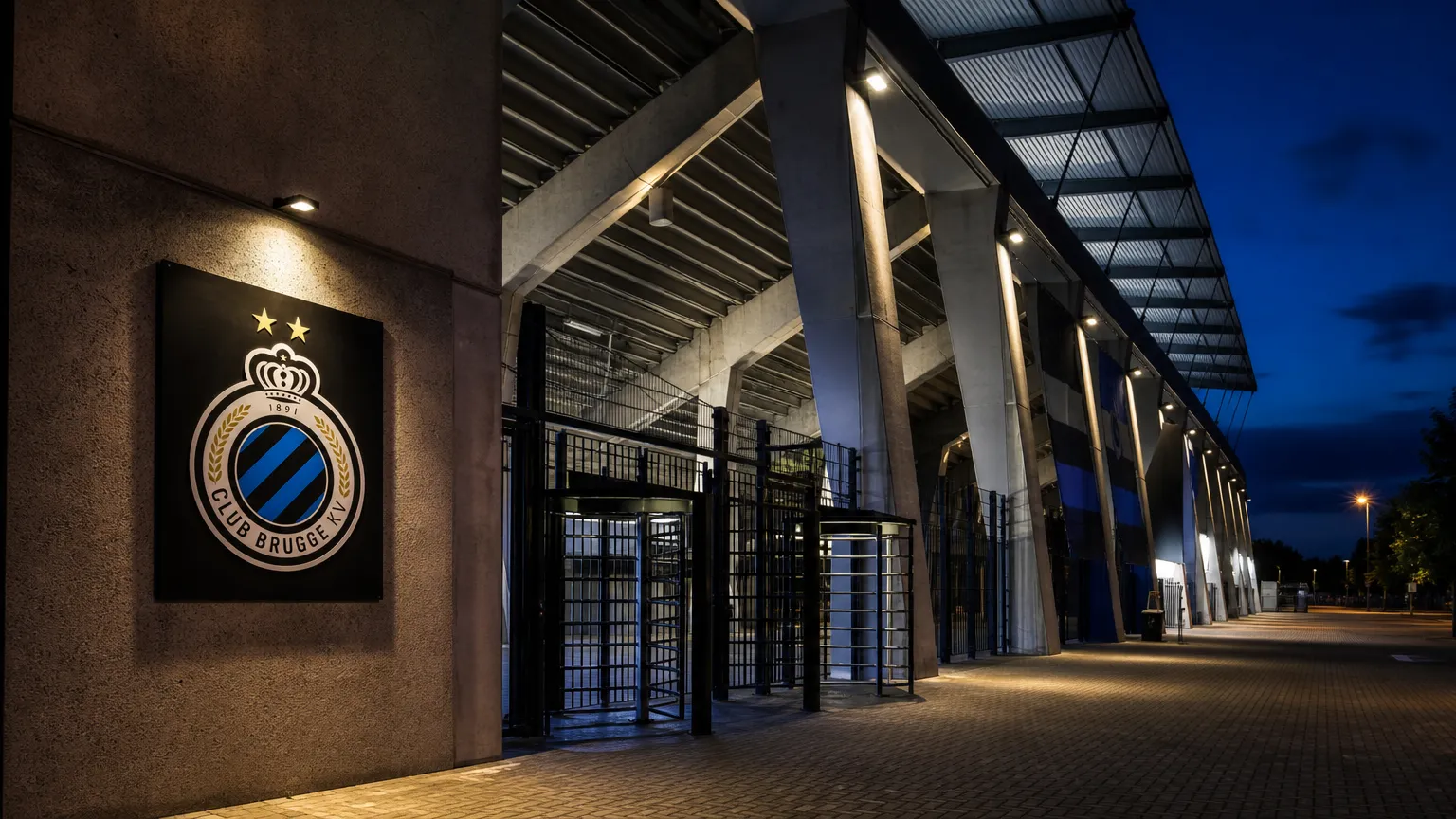 Verlichte ingang van een stadion van Club Brugge in de avond.