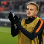 Noa Lang tijdens een opwarming langs de zijlijn in neutrale trainingskleding.