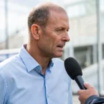 Jess Thorup spreekt tijdens een voetbalinterview in een lichte hemd.