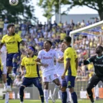 Spelers van Union en Zulte Waregem verdedigen samen een hoekschop voor doel.