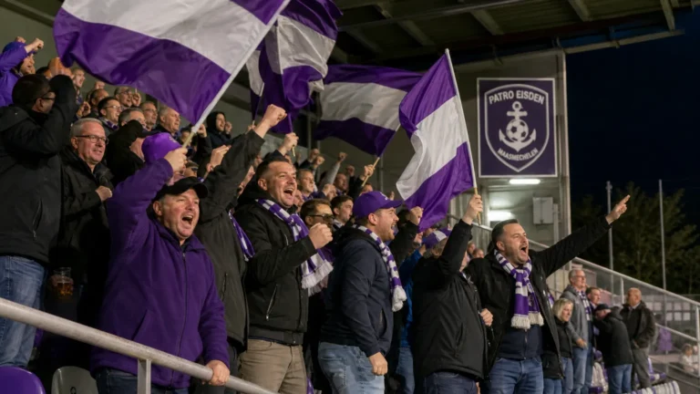 Supporters van Patro Eisden zwaaien met paars-witte vlaggen in de tribune.