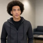 Axel Witsel in neutrale sportieve kleding in een rustige professionele binnenruimte.