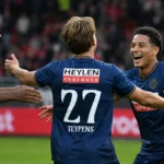 Drie spelers van Royal Antwerp FC vieren samen een doelpunt op het veld.
