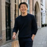 Hanbeom Lee wandelt met een neutrale boodschappentas door een Brugse winkelstraat.