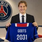 Mika Godts houdt tijdens zijn voorstelling bij Paris Saint-Germain een PSG-shirt omhoog.