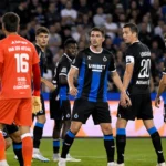 Spelers van Club Brugge groeperen zich bij het doel tijdens een wedstrijd.