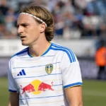 Sebastiaan Bornauw in het tenue van Leeds United langs een voetbalveld.