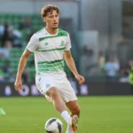 Lucas Stassin warmt op in een groen-wit voetbaltenue op het veld.
