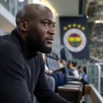 Romelu Lukaku kijkt geconcentreerd naar het veld vanuit de tribune van het stadion.